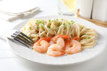 Delicious pasta with shrimps and green onions on white wooden table, closeup