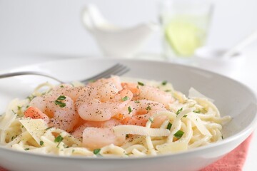 Delicious pasta with shrimps and cheese on table, closeup