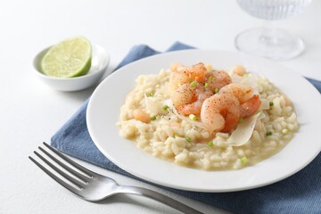 Delicious risotto with shrimps and cheese on white table, closeup