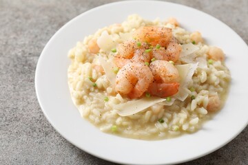 Delicious risotto with shrimps and cheese on grey table, closeup