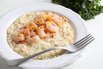 Delicious risotto with shrimps and cheese on white table, closeup