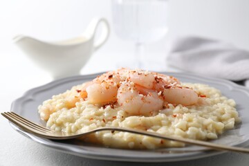 Delicious risotto with shrimps and cheese on white table, closeup