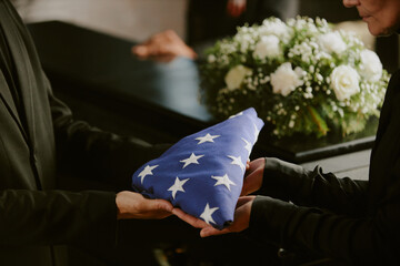 Unrecognizable female hands giving American flag to pastor