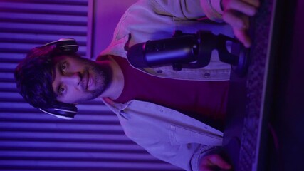Vertical video: A skilled gamer engages in an immersive gaming session, showcasing expert strategies while surrounded by vibrant, colored lighting. The atmosphere enhances the gaming experience as he
