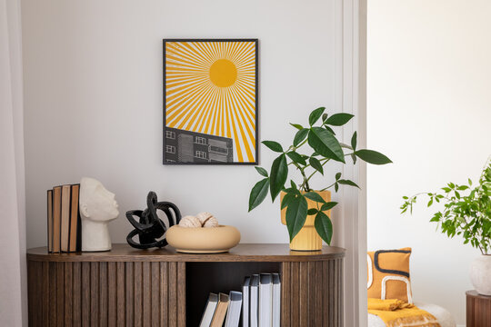 Naklejki Stylish interior with a wooden cabinet adorned with potted plants, decorative objects, and books. A vibrant art piece featuring a sunburst design adds a pop of color. Cozy seating area.