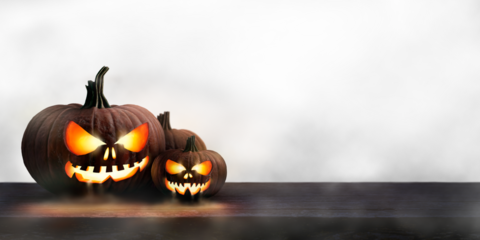 Two lit Jack-o-Lantern, halloween pumpkin lanterns on a wooden product display table with mist an isolated transparent background.