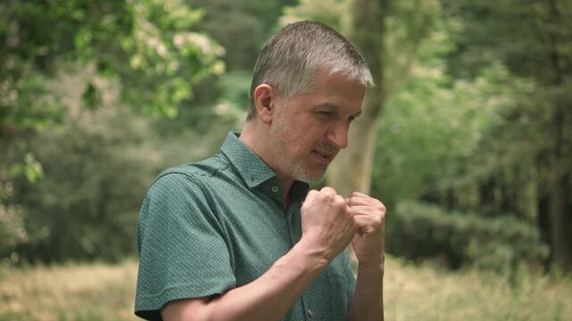 Motivational footage with a man standing in nature and cheering himself on. Dynamic and encouraging body language, slow motion