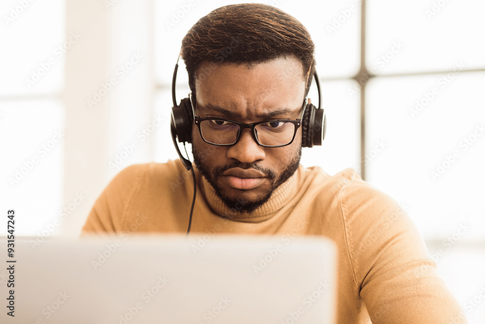 Poster helpline concept. focused african call center agent consulting client looking at laptop. empty space