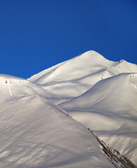 Off-piste slope and blue clear sky in nice winter morning