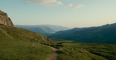 Naklejka premium Hiking trail winding through lush green valley in the mountains