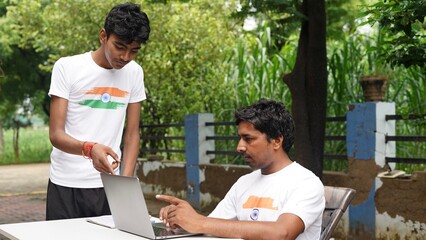 Indian School kids E-learning using laptop. Children doing homework at garden in computer.