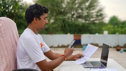 Indian young man doing payment with smartphone using QR code