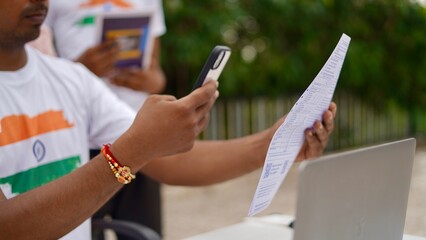 Indian young man doing payment with smartphone using QR code