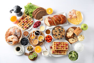 Different meals served for breakfast on white table, flat lay