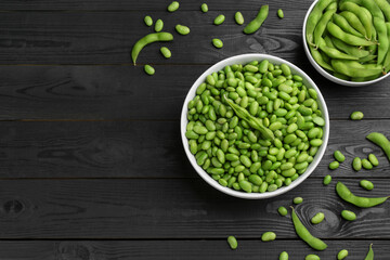 Raw green edamame soybeans and pods on wooden table, flat lay. Space for text