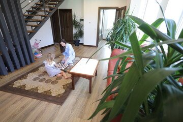 Mother and a child playing chess at home