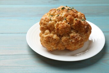 Delicious baked cauliflower on light blue wooden table