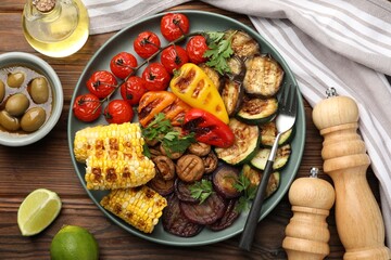 Delicious grilled vegetables served on wooden table, flat lay