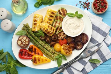 Delicious grilled vegetables served on light blue wooden table, flat lay