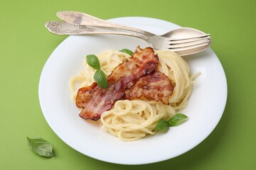 Delicious pasta Carbonara served on green table, closeup