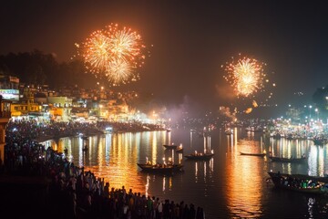 Fireworks lighting up the night sky over a festive riverside