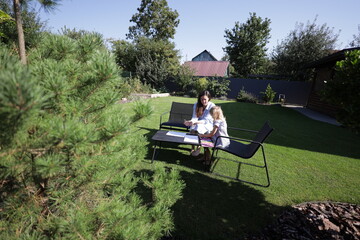 Mother and a child drawing in the backyard