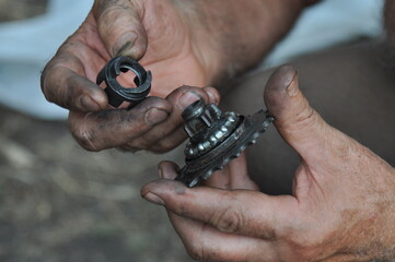 Fototapeta premium The man fixing his old bike. Process of replacing the rear sprocket of an old bicycle. Relaxing hobby and good time. 
