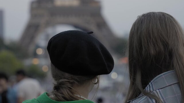 Female tourist wearing beret (French hat) and dress  chilling and looking at Eiffel tower Paris, France in slow motion