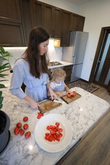 Mother and a small daughter cooking food at home in the kitchen