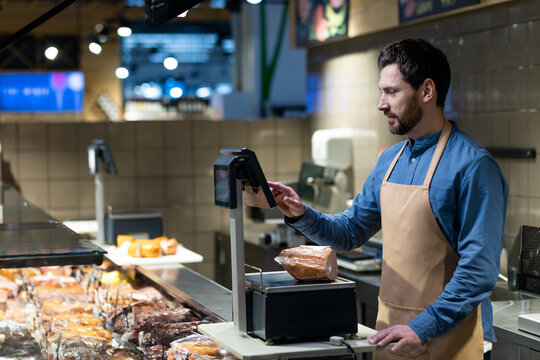 Butcher working in grocery store using digital scales to weigh deli meats. Scene shows professional in apron managing customer orders behind counter filled with packaged products under bright lights. - Powered by Adobe