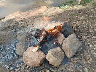 Ben Smim, Morocco - August 8, 2024: Lighting a barbecue fire in the middle of the Moroccan Middle Atlas Mountains, with the sound of running water creating an atmosphere of serenity and nature