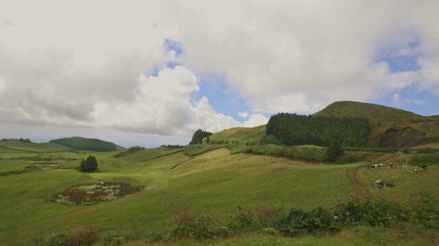Clouds shifting gracefully over a serene green landscape