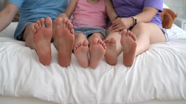Three barefoot people, mother, father and daughter resting on the sofa, foot closeup, corns and calluses on feet, dry skin on legs, cracked heels, body care concept