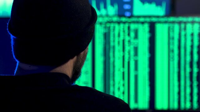 Computer hacker tying code onto a screen
