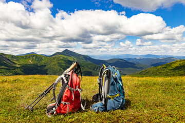Hiking in the mountains with two backpacks in the summer.