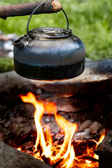 Coffee pot on a campfire during a hike in the mountains.