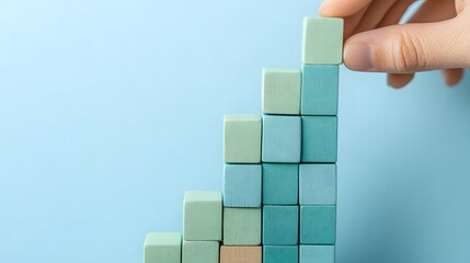  Strategic business growth concept with hand placing green and blue blocks to build an upward graph representing success in marketing and sales. Business planning, and positive trends