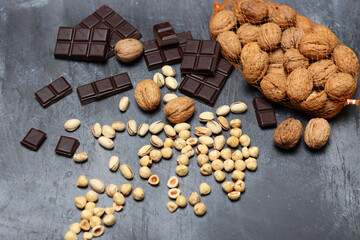 Different types of nuts on a table. Walnut, hazelnut, pistachio on grey textured background with copy space. Eating healthy concept. 