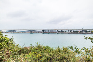 Expansive Bridge Over Tranquil Waters Under Cloudy Skie