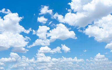 A bright blue sky with fluffy white clouds on a sunny day