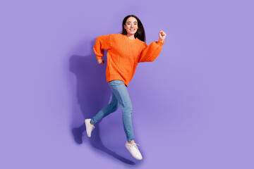 Photo of positive lovely cute girl wear trendy clothes run fast isolated on violet color background