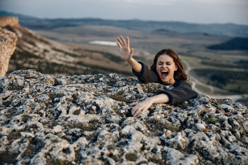 Achieving serenity woman lying on mountaintop with arms raised in victory