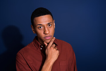 Photo of young man ponder think wear brown shirt isolated on dark blue color background