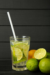 Glass of fresh mojito on black wooden background. Vertical photo