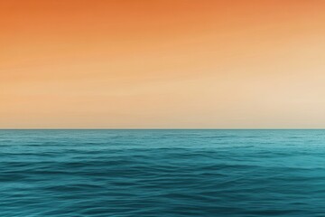 Obraz premium A gradient moving from a warm orange to a cool teal with a subtle grain effect, resembling a sunset over the ocean.