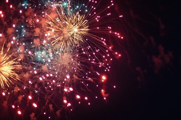 Fototapeta premium Fireworks Display in Night Sky with Red and Gold Sparks