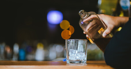 Whiskey drinks at the bar celebrating a special event in a luxury bar. Close-up shows a cheerful atmosphere as glasses clink together, reflecting a lively and joyful gathering.