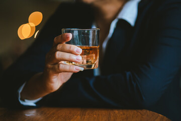 Whiskey drinks at the bar celebrating a special event in a luxury bar. Close-up shows a cheerful atmosphere as glasses clink together, reflecting a lively and joyful gathering.