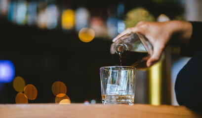 Whiskey drinks at the bar celebrating a special event in a luxury bar. Close-up shows a cheerful atmosphere as glasses clink together, reflecting a lively and joyful gathering.