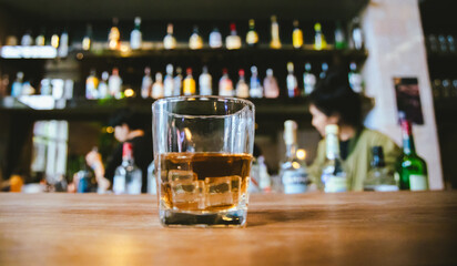 Whiskey drinks at the bar celebrating a special event in a luxury bar. Close-up shows a cheerful atmosphere as glasses clink together, reflecting a lively and joyful gathering.